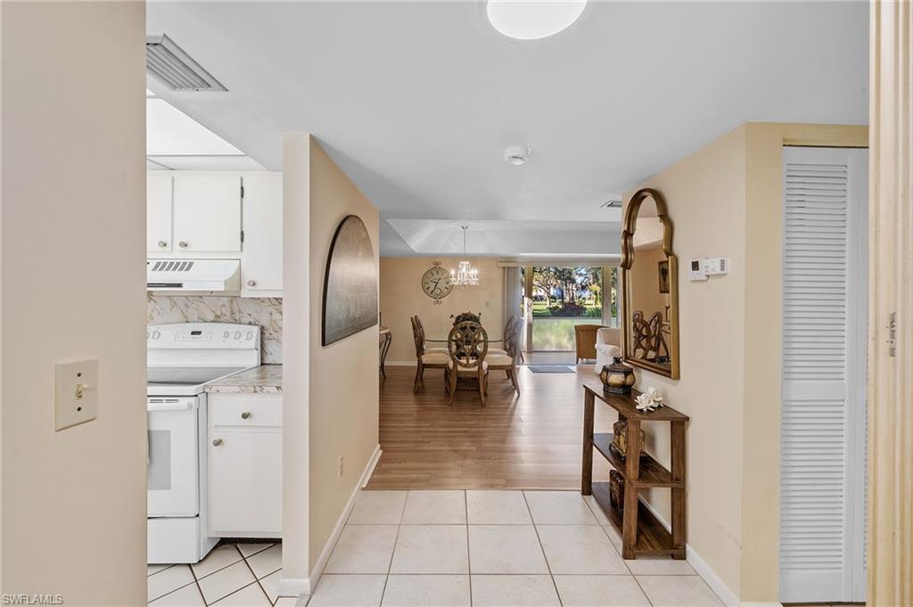 817 Teryl Road, Unit 1 Naples, FL 34112 - Photo 5 of 47 a hallway with white doors and chandelier