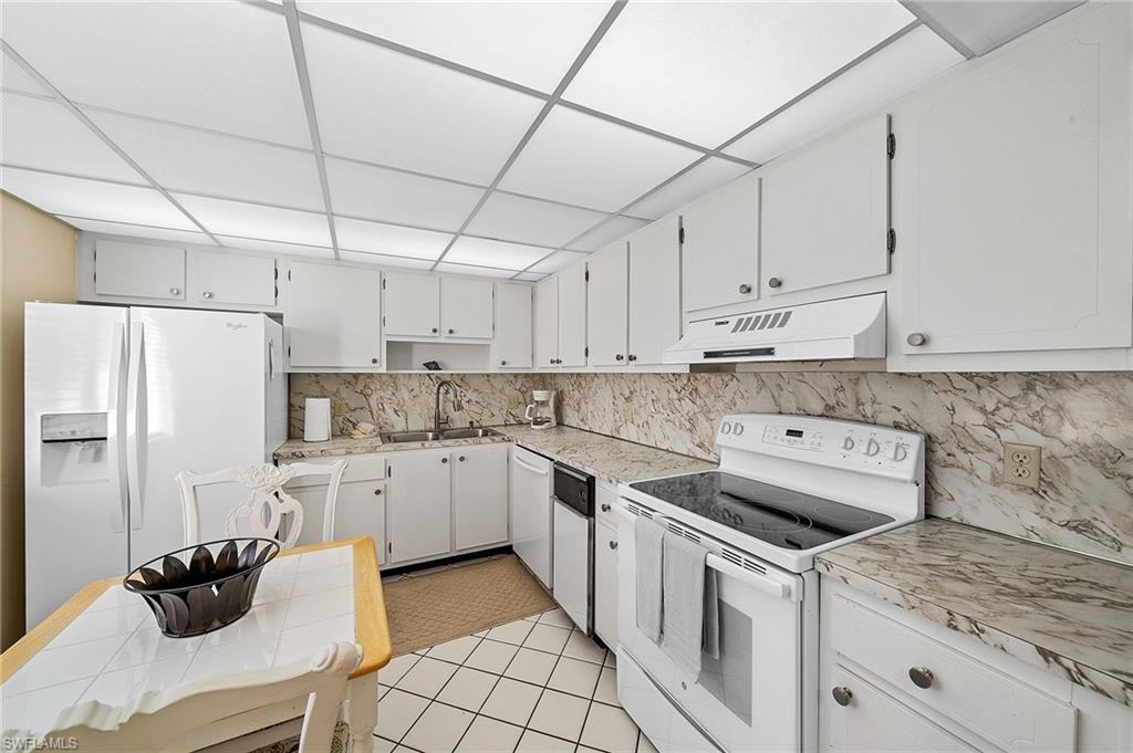 817 Teryl Road, Unit 1 Naples, FL 34112 - Photo 6 of 47 a kitchen with a sink white cabinets and white appliances