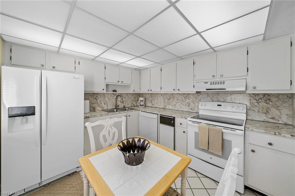 817 Teryl Road, Unit 1 Naples, FL 34112 - Photo 9 of 47 a kitchen with a white stove top oven and white cabinets
