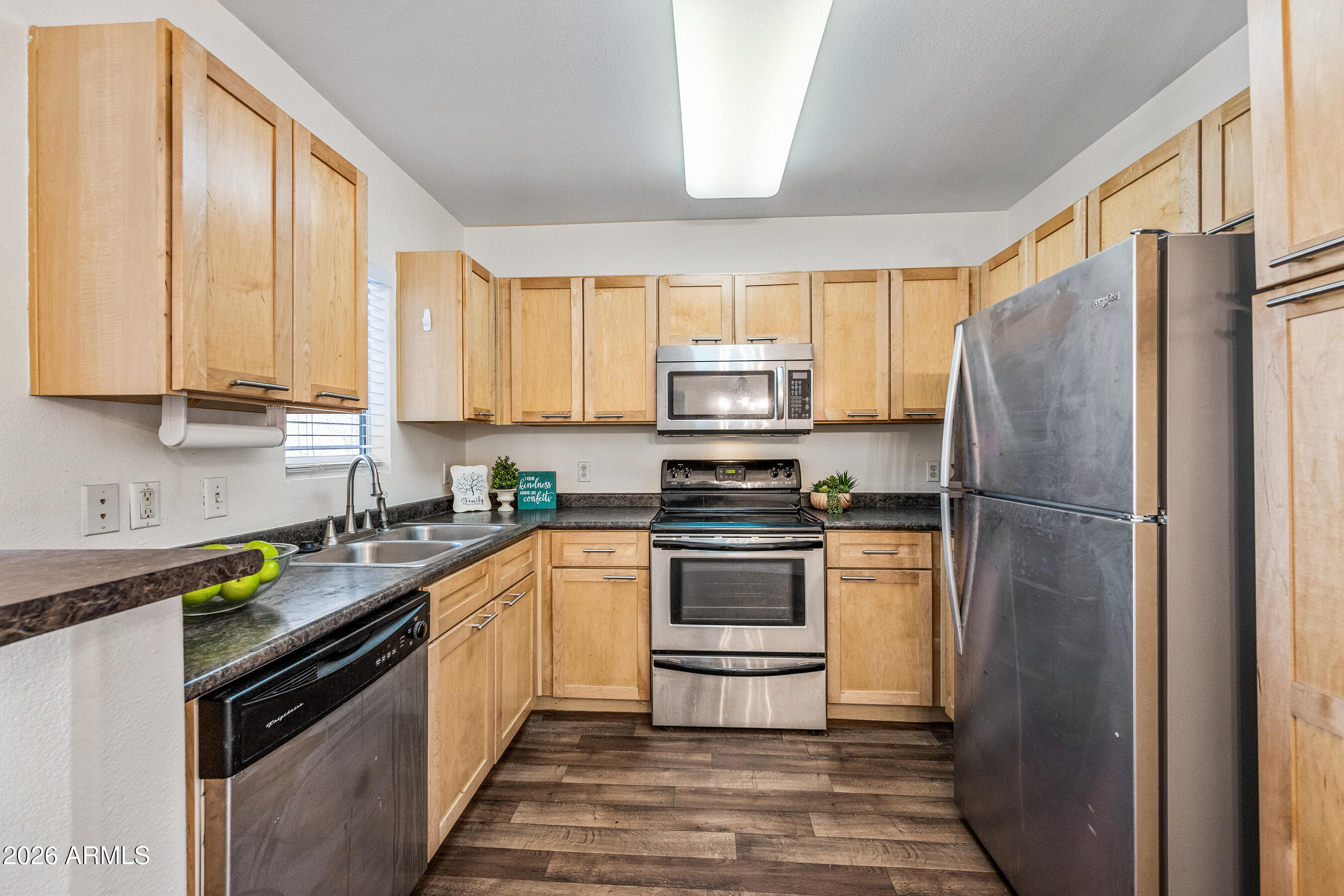 a kitchen with stainless steel appliances granite countertop a refrigerator sink and stove