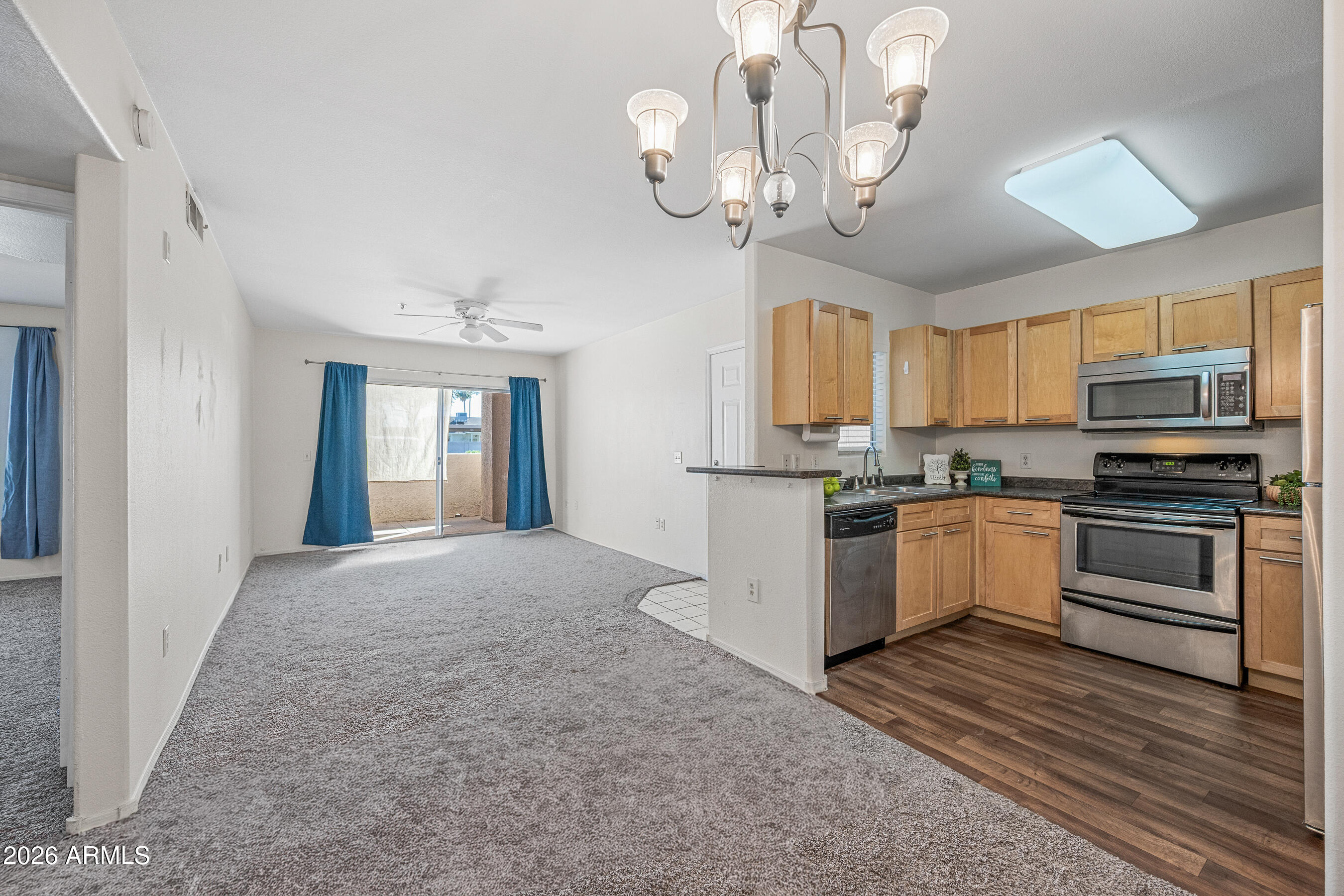 1295 North Ash Street, Unit 617 Gilbert, AZ 85233 - Photo 3 of 21 a kitchen with a chandelier stainless steel appliances cabinets and a counter top space