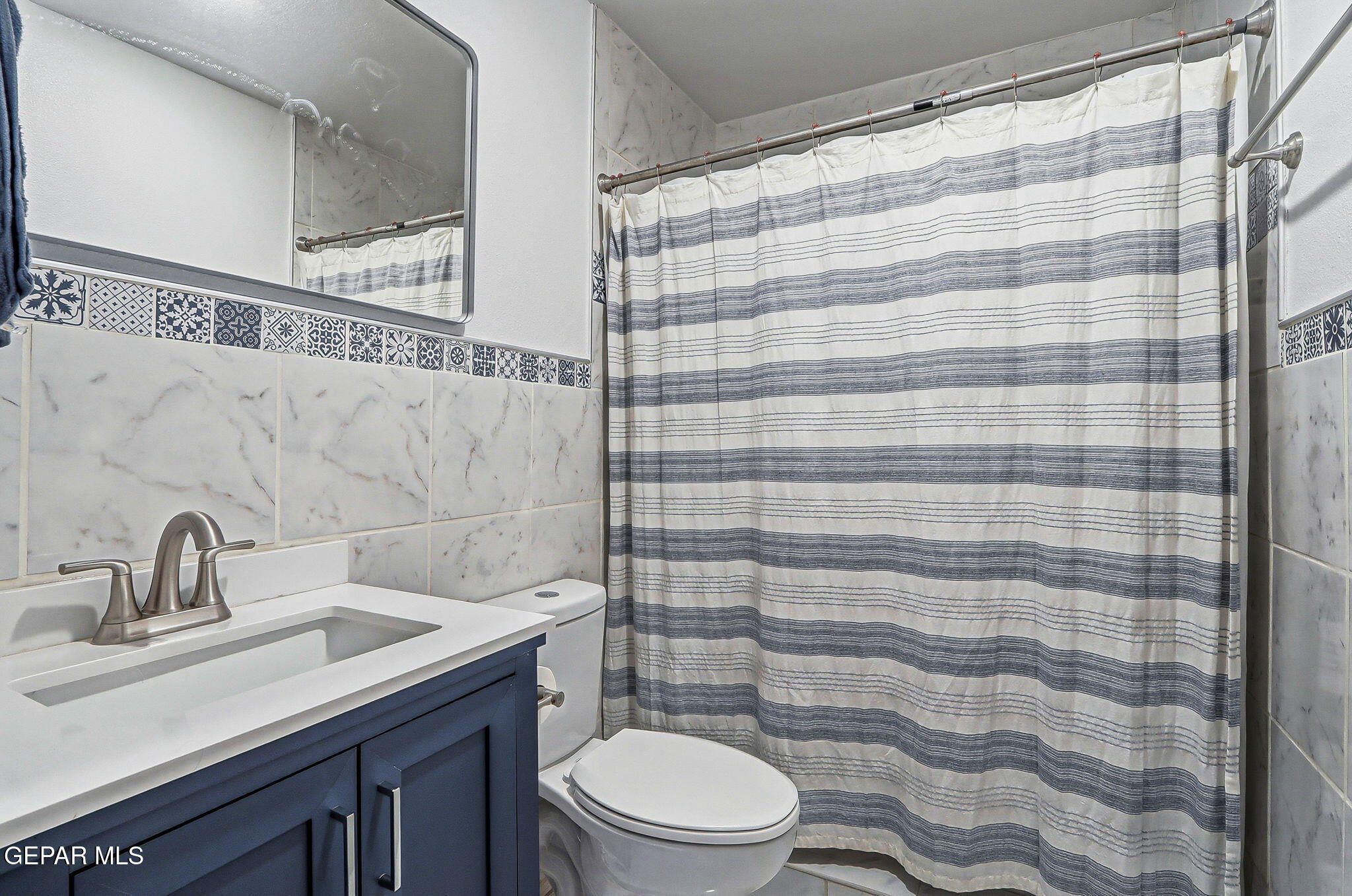 10540 Socorro Road Socorro, TX 79927 - Photo 11 of 45 a bathroom with a sink a toilet and shower curtain