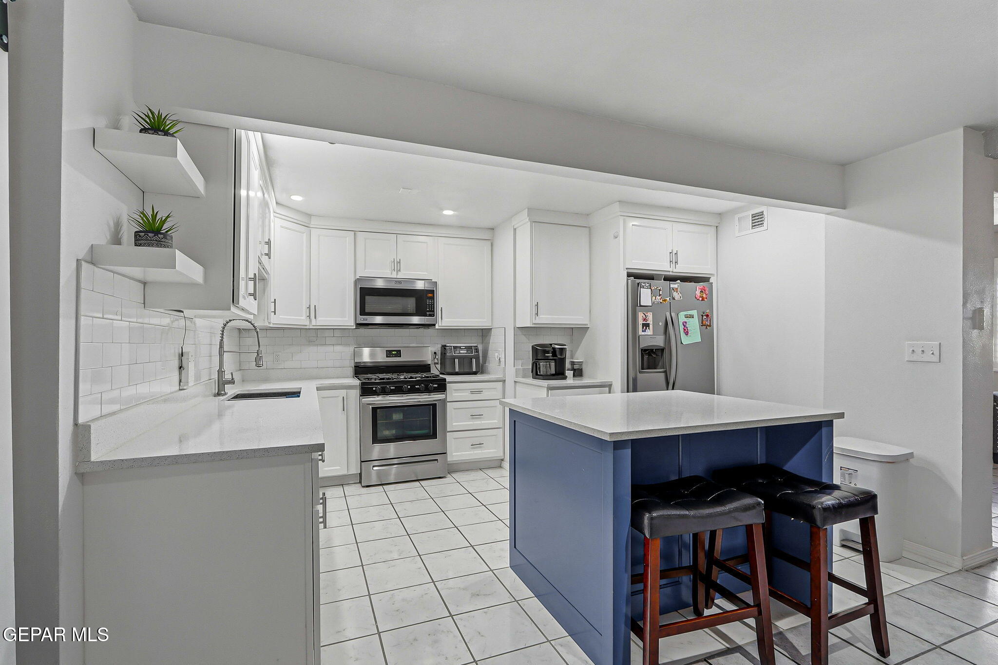 10540 Socorro Road Socorro, TX 79927 - Photo 2 of 45 a kitchen with stainless steel appliances a stove a sink refrigerator and a refrigerator with wooden floor