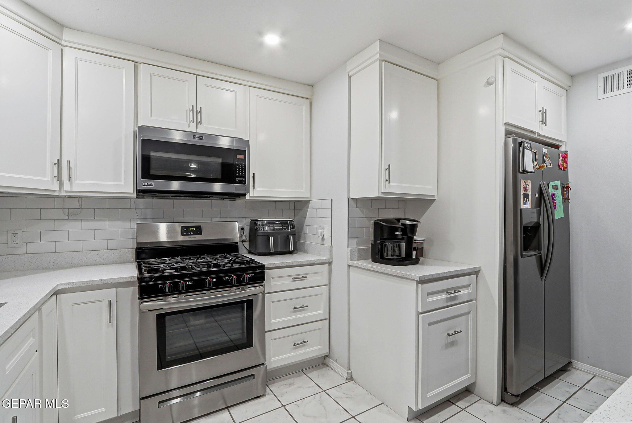 10540 Socorro Road Socorro, TX 79927 - Photo 4 of 45 a kitchen with white cabinets and appliances