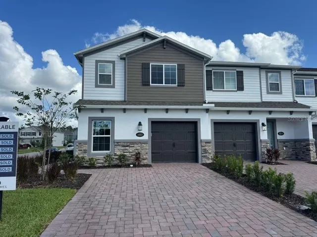 a front view of a house with a yard and a garage