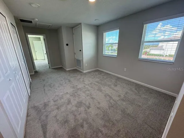 an empty room with windows and closet