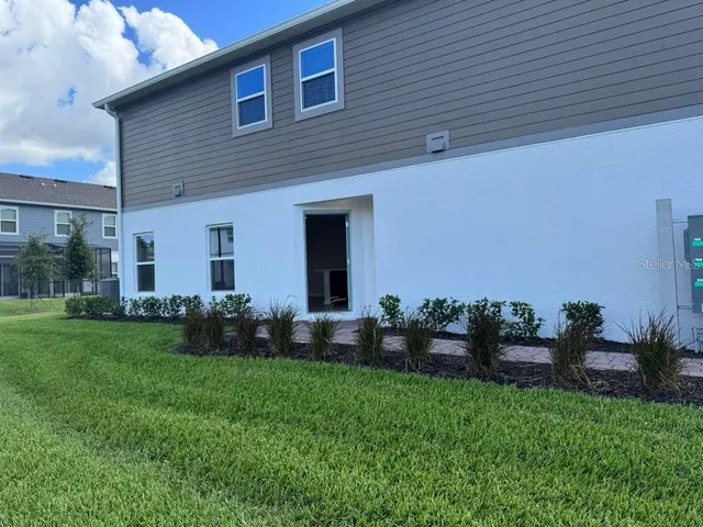 a view of a house with a yard and tree s