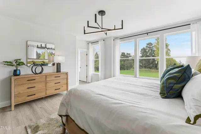 a bedroom with a bed a table and flat screen tv