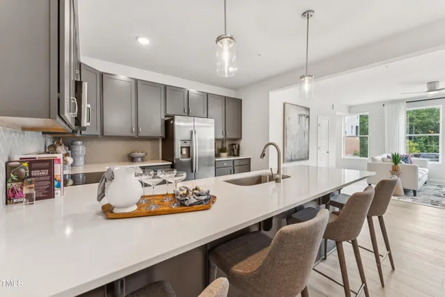 a kitchen with kitchen island a sink stove and refrigerator