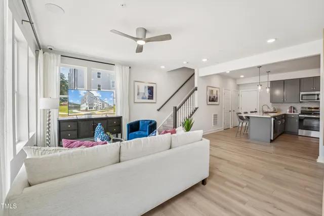 a kitchen with sink a refrigerator and chairs