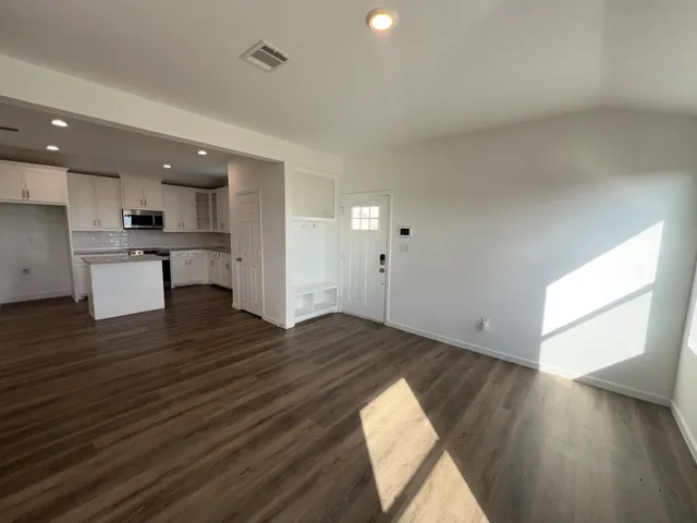 a view of empty room with wooden floor