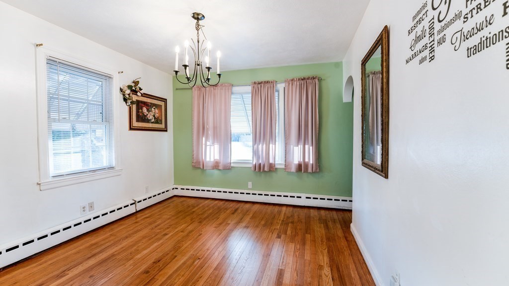 181 Laurelton Street Springfield, MA 01109 - Photo 8 of 17 a view of a room with wooden floor chandelier and windows