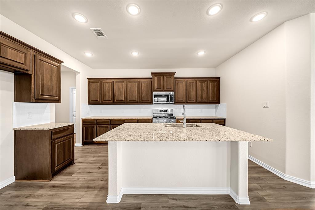 3516 Columbus Street Gainesville, TX 76240 - Photo 12 of 40 a view of kitchen with stainless steel appliances granite countertop cabinets and wooden floor