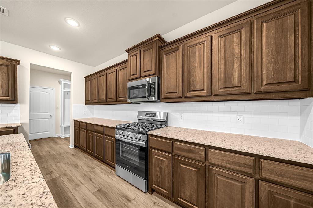3516 Columbus Street Gainesville, TX 76240 - Photo 14 of 40 a kitchen with stainless steel appliances granite countertop a sink stove and cabinets