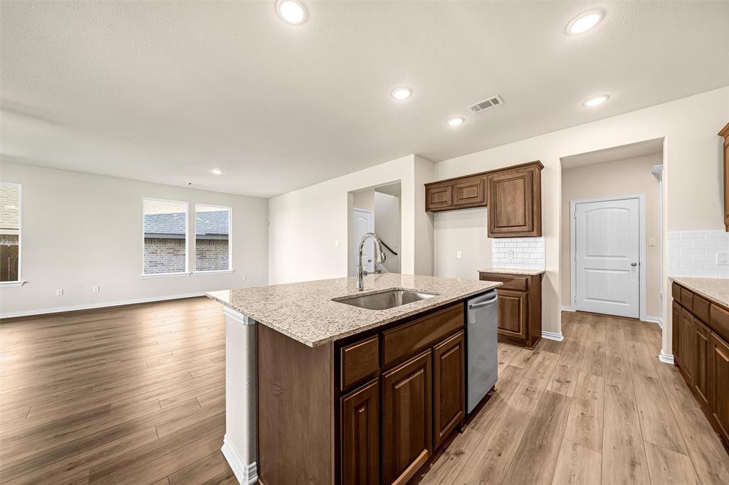 3516 Columbus Street Gainesville, TX 76240 - Photo 39 of 40 a kitchen with stainless steel appliances granite countertop a sink stove and wooden floor