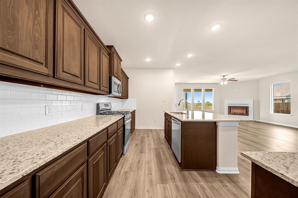 3516 Columbus Street Gainesville, TX 76240 - Photo 40 of 40 a kitchen with stainless steel appliances granite countertop wooden cabinets a stove top oven and granite counter tops