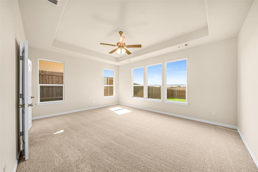 3516 Columbus Street Gainesville, TX 76240 - Photo 16 of 40 an empty room with windows and chandelier fan