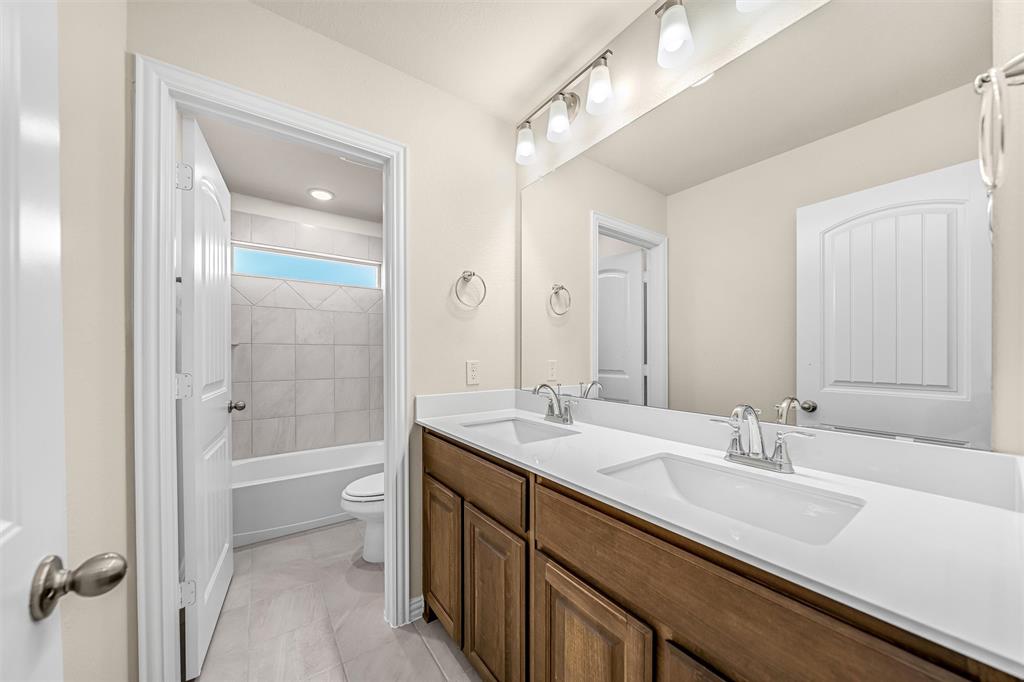 3516 Columbus Street Gainesville, TX 76240 - Photo 26 of 40 a bathroom with a sink a toilet and shower