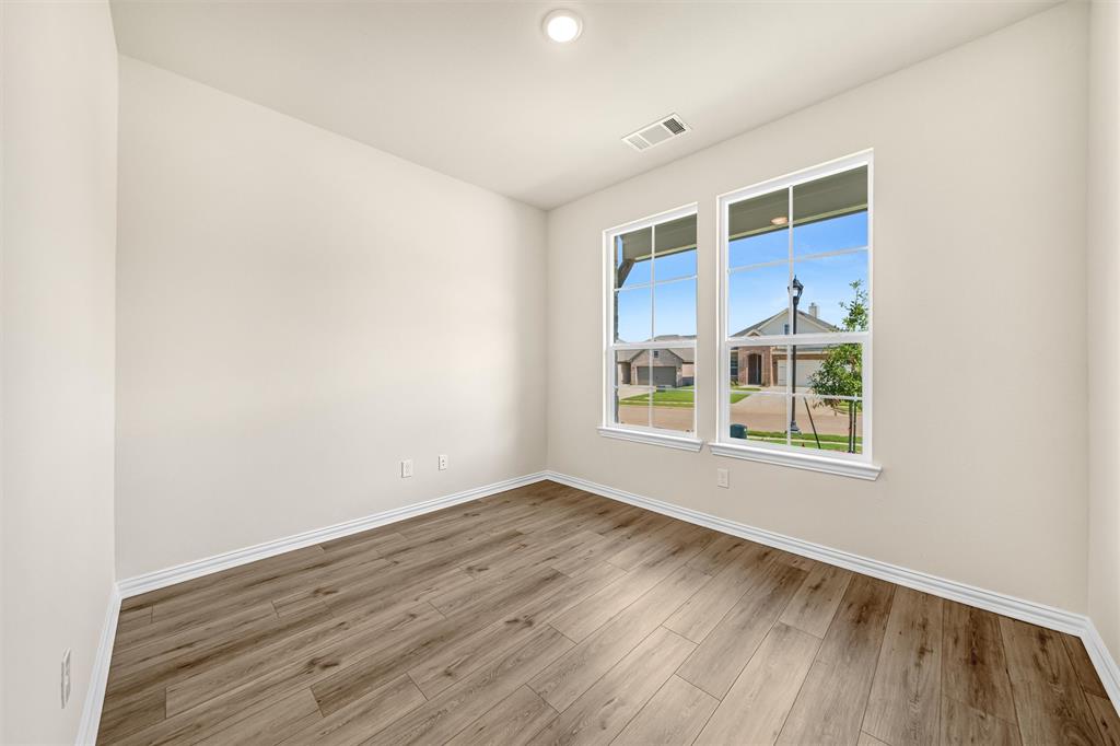 3516 Columbus Street Gainesville, TX 76240 - Photo 7 of 40 a view of an empty room with a window and wooden floor