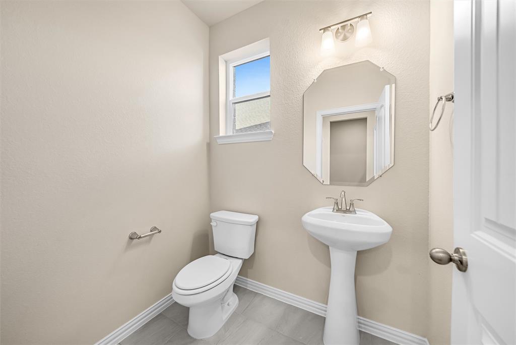 3516 Columbus Street Gainesville, TX 76240 - Photo 8 of 40 a bathroom with a toilet sink and mirror