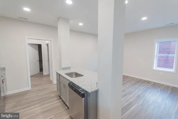 a kitchen with a sink and wooden floor