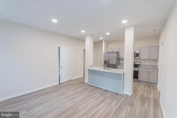 a large kitchen with a lot of counter space and wooden floor