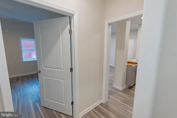 a view of a hallway with wooden floor and closet
