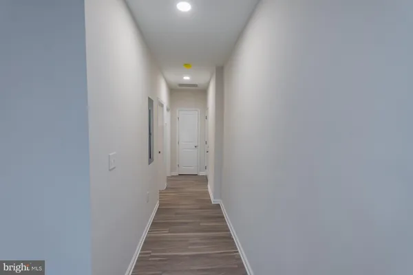 a view of a hallway with wooden floor