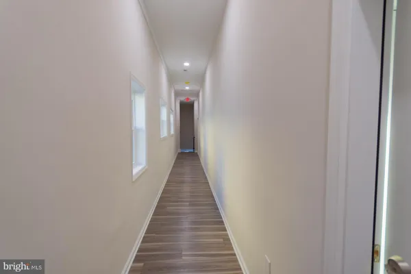 a view of a hallway with wooden floor
