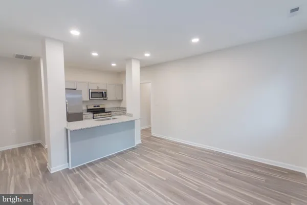 a kitchen with a refrigerator and white cabinets