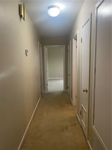 an empty room with a fan & a window