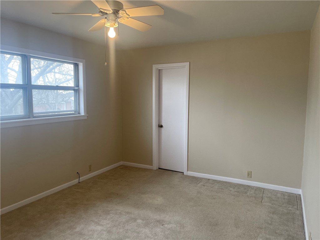 1008 North Bosque Street Meridian, TX 76665 - Photo 7 of 36 an empty room with a chandelier fan and windows