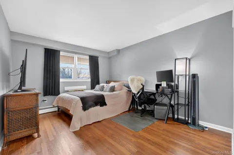 a spacious bedroom with a bed and wooden floor