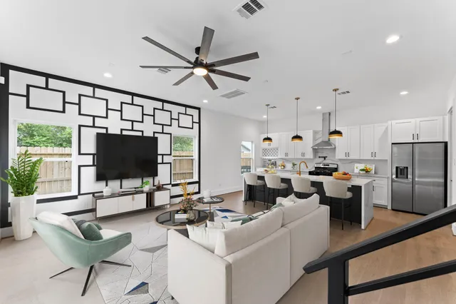 a living room with furniture a flat screen tv and a window