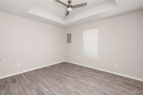 an empty room with a window and a ceiling fan