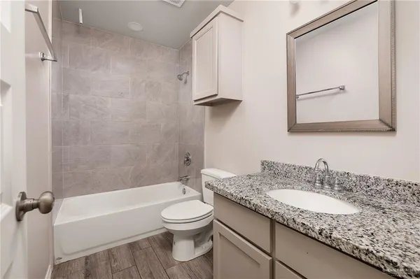 a bathroom with a granite countertop sink toilet and shower
