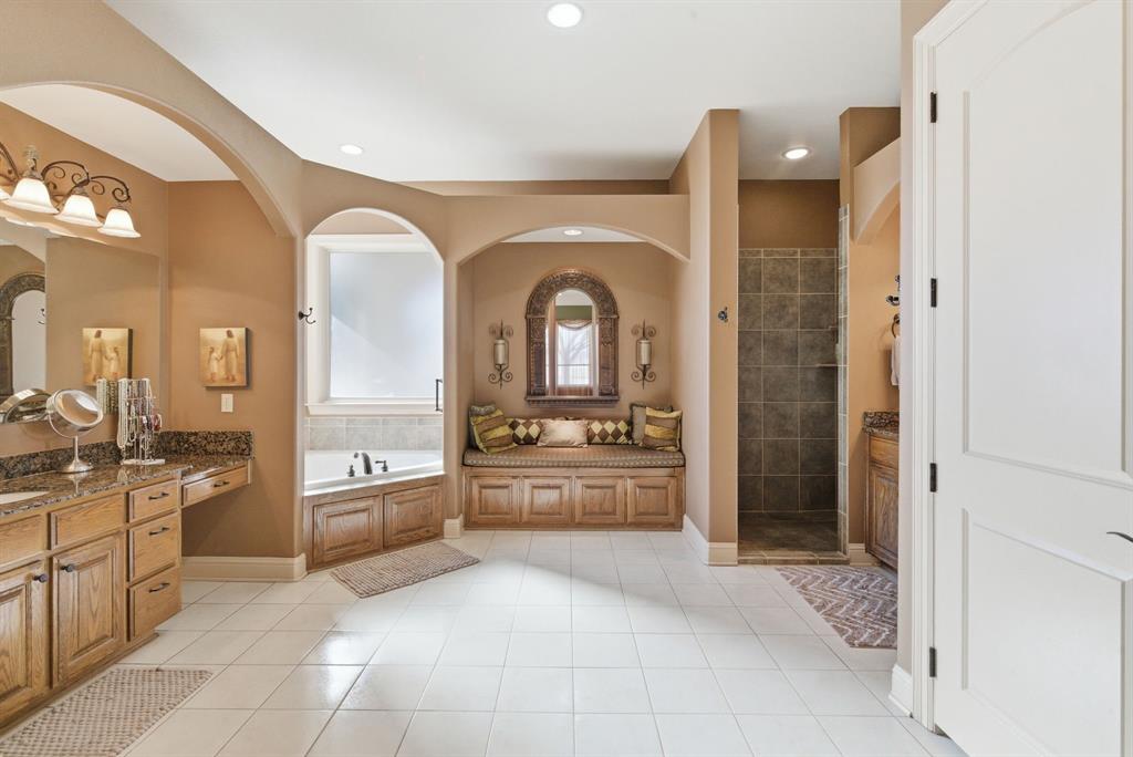 3601 Springfield Road Springtown, TX 76082 - Photo 11 of 40 a large en suite bathroom with a granite countertop tub a sink and a large mirror