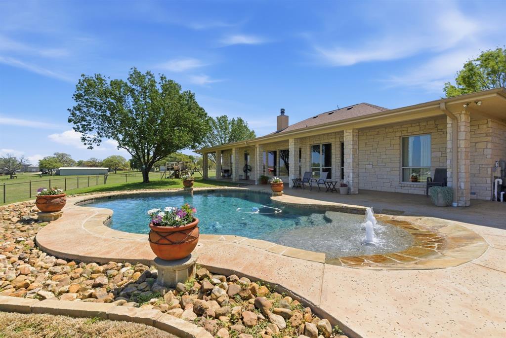 3601 Springfield Road Springtown, TX 76082 - Photo 2 of 40 a view of a house with swimming pool and sitting area