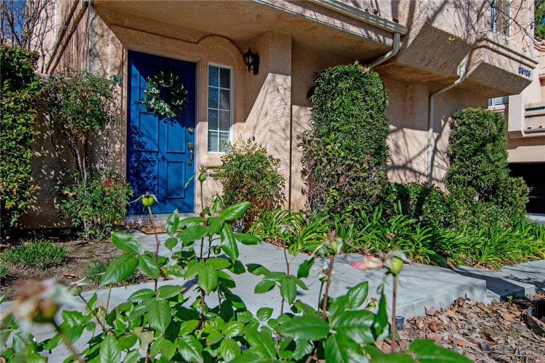25126 Steinbeck Avenue, Unit H Stevenson Ranch, CA 91381 - Photo 1 of 22 a view of a house with a small yard and plants