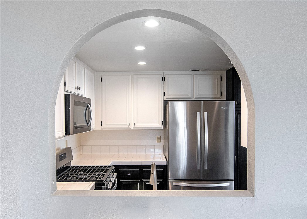 25126 Steinbeck Avenue, Unit H Stevenson Ranch, CA 91381 - Photo 8 of 22 a kitchen with kitchen island a refrigerator and a stove