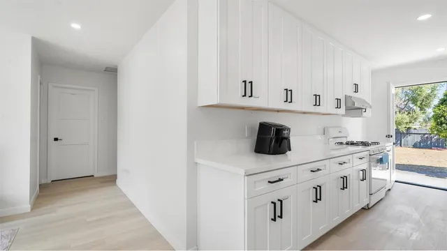 a kitchen with white cabinets a sink and dishwasher