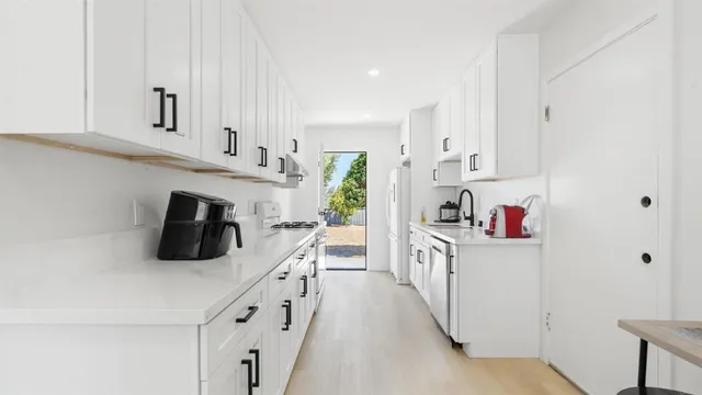 a kitchen with stainless steel appliances granite countertop a sink and a refrigerator