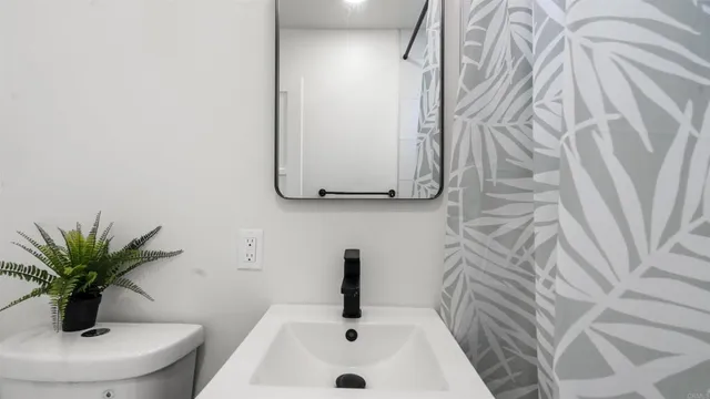a bathroom with a sink a toilet and a mirror