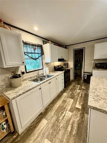 a large kitchen with granite countertop a sink stainless steel appliances and cabinets