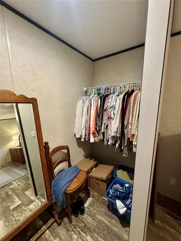 a view of walk in closet with clothes and shoes