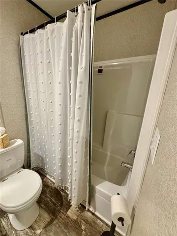 a bathroom with a toilet and a shower