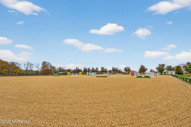 a view of a white house with a big yard and large trees