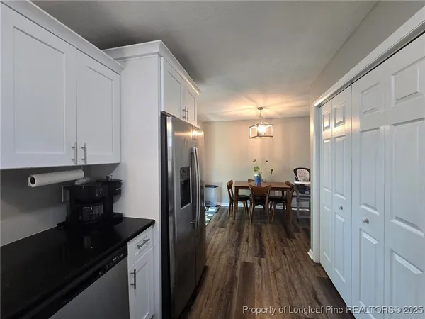 a view of a livingroom with wooden floor and a workspace