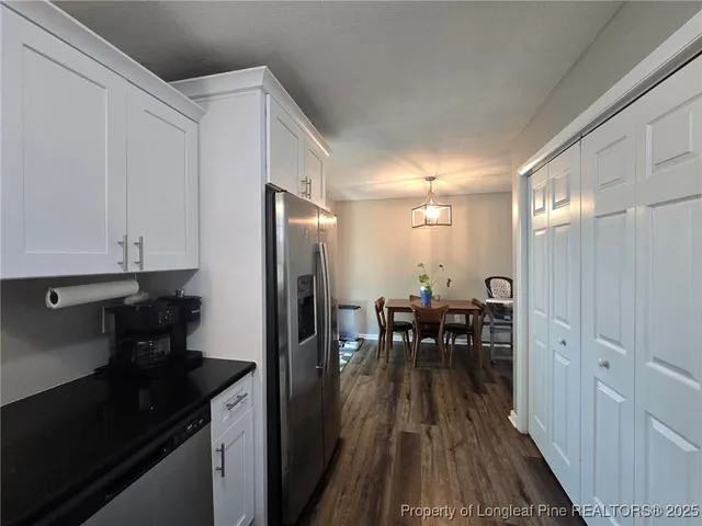 a view of a livingroom with wooden floor and a workspace
