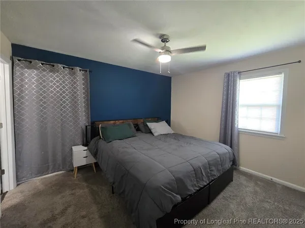 a bedroom with a bed and a flat tv screen on dresser